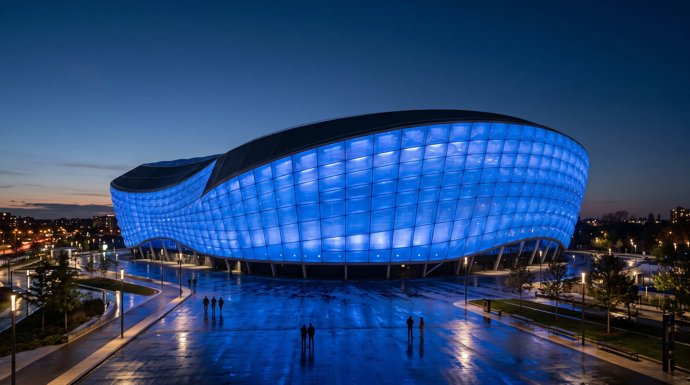 Un grand stade contemporain au crépuscule, son enveloppe extérieure entièrement baignée d'une lumière DEL uniforme, les contours de l'architecture nettement dessinés
