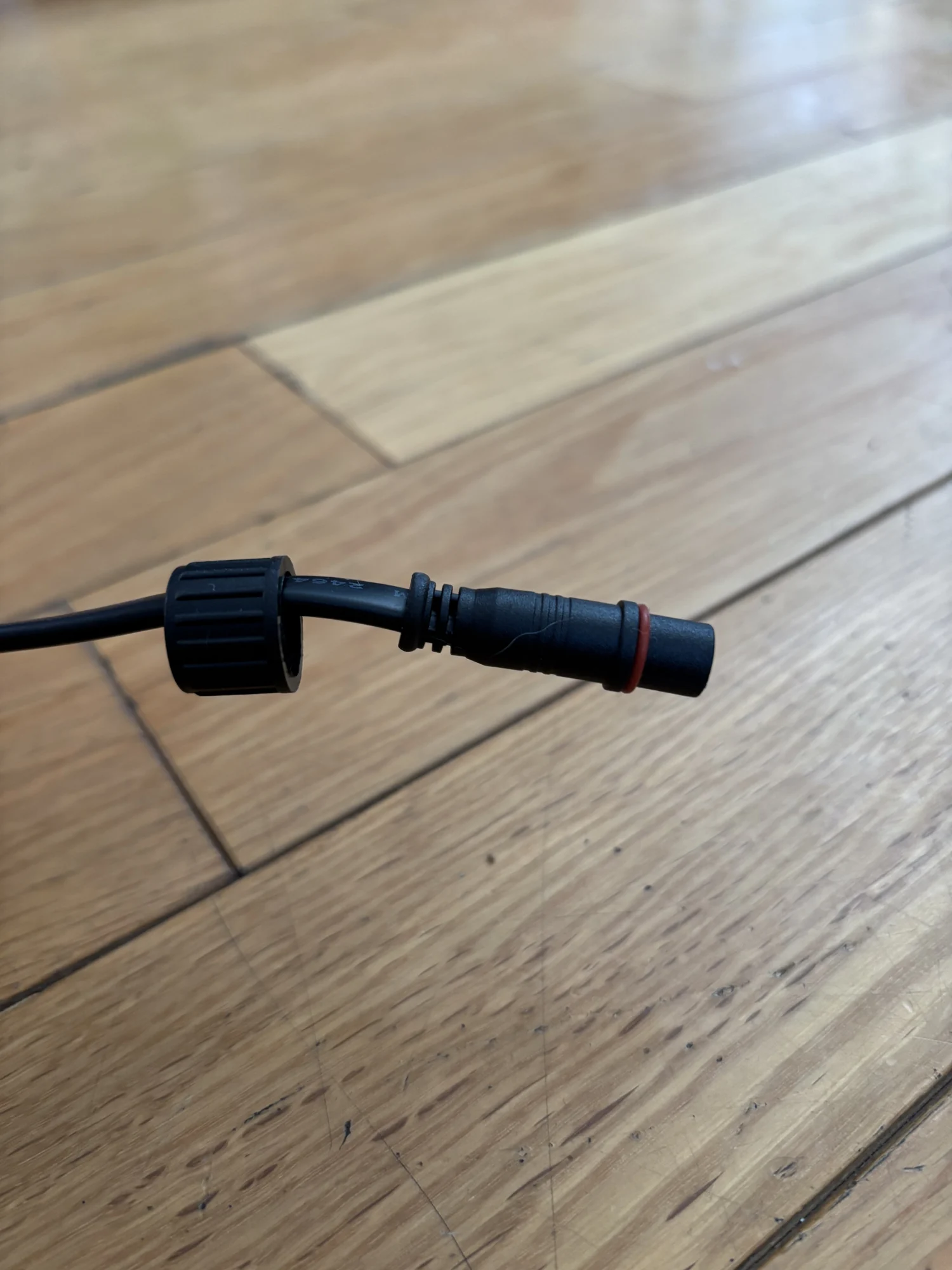 Gros plan d’un connecteur étanche à bague vissée, au bout d’un câble du kit