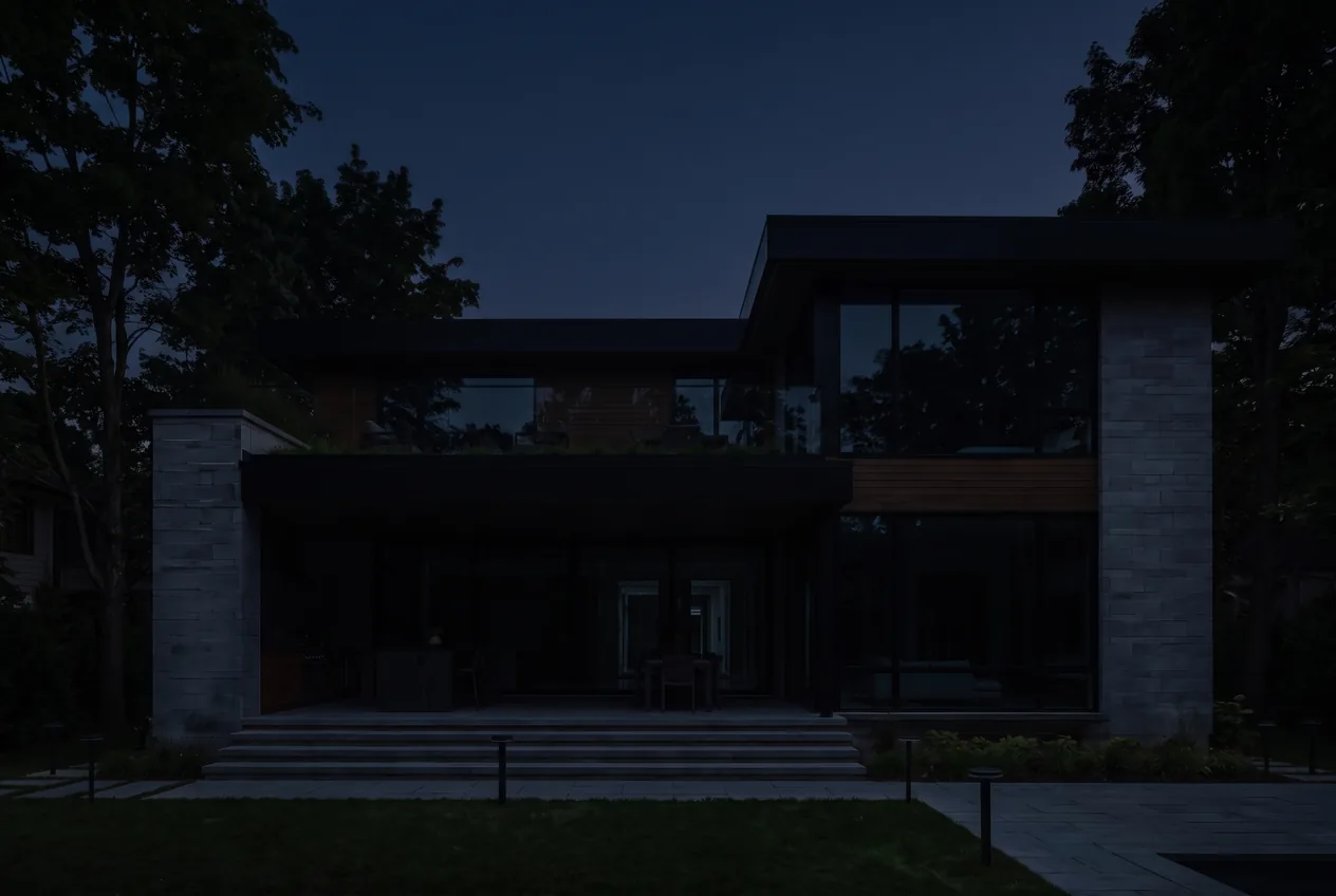 Modern stone and wood home at night with every light switched off, almost disappearing into the darkness