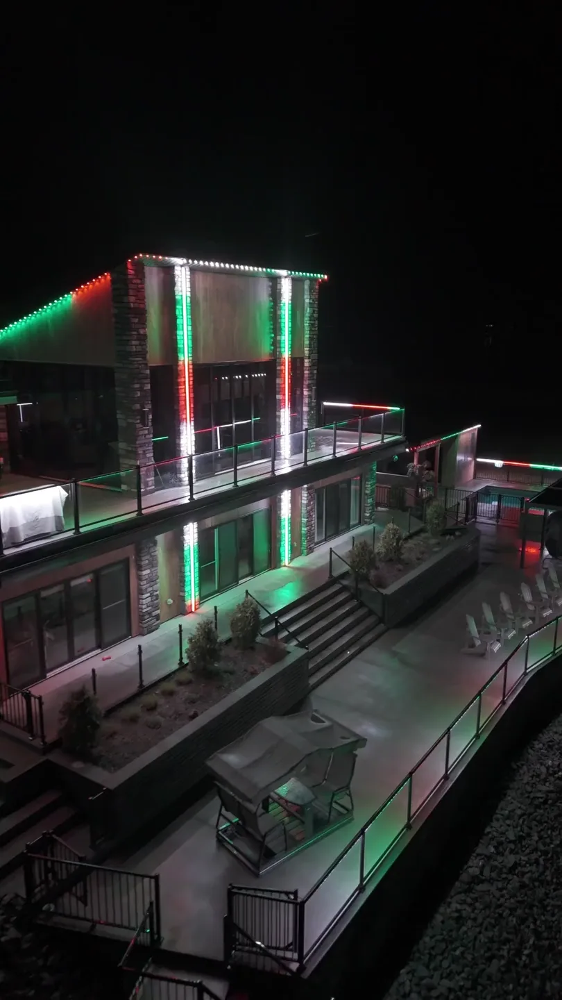 Home lit in red and green for the holidays, every pixel along the roofline and gables addressed separately