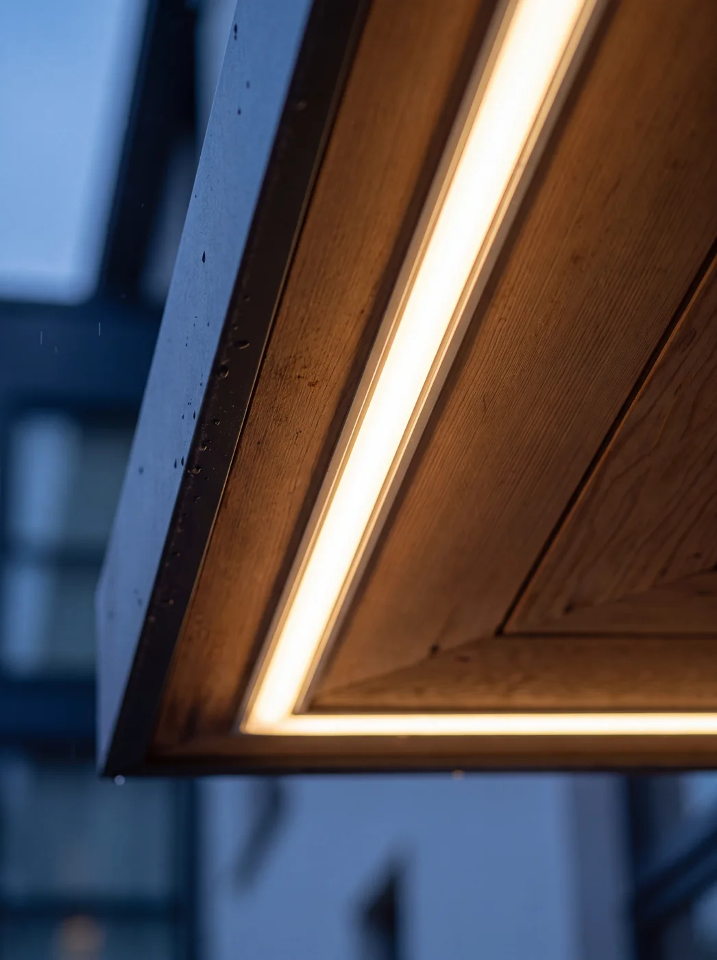 Warm-white LED seated flush inside a colour-matched aluminium channel recessed into a wood soffit — fixture nearly invisible