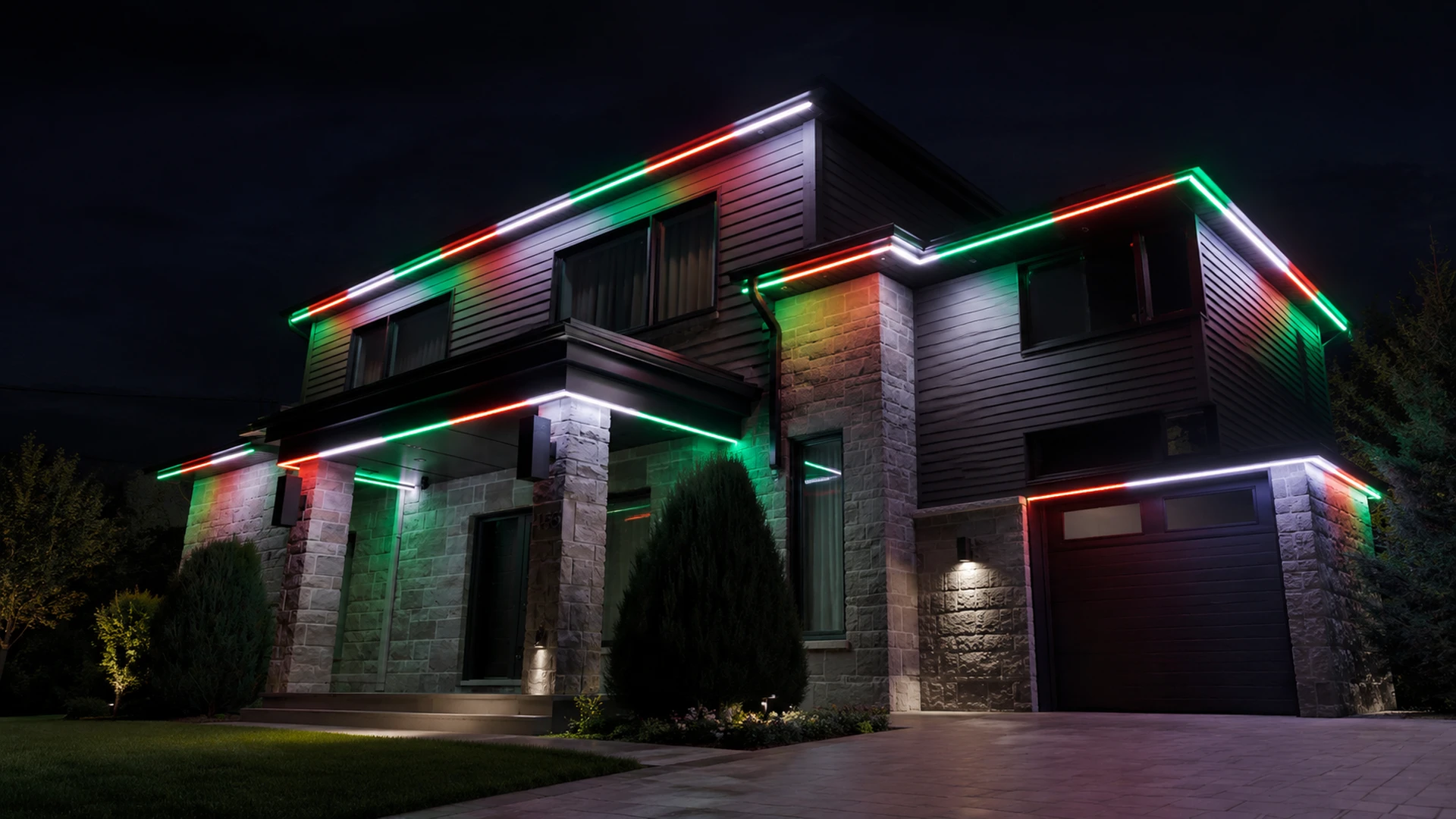 Two-storey stone and dark-clad home at night, every roofline and soffit outlined by permanent LED in red, green and white segments