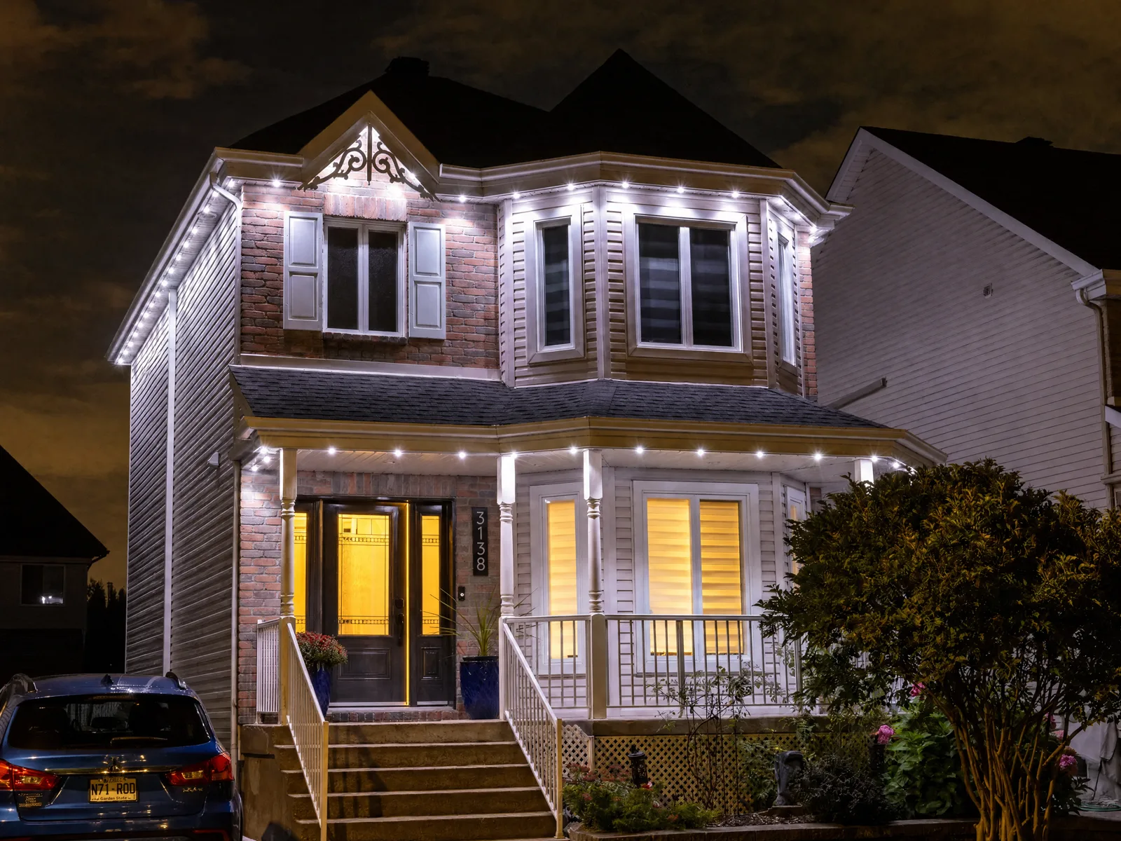 Victorian-style home at night with cool-white permanent LED points outlining the rooflines, bay windows and front porch — a Québec install